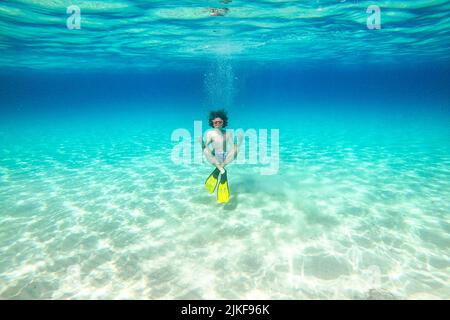 Unterwasserfoto eines Jungen mit Schnorchelflossen und Skibrillen in Yoga-Pose auf einem wunderschönen Veli ZAL Strand, Dugi otok, Kroatien Stockfoto