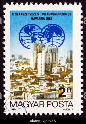 UNGARN - UM 1982: Eine in Ungarn gedruckte Briefmarke, die für den Weltgewerkschaftsföderationskongress 10. in Havanna ausgegeben wurde, zeigt das Kongressemblem und Havanna. Stockfoto