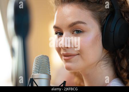 Porträt einer glücklichen jungen Radiosprecherin, die im Studio sendet Stockfoto