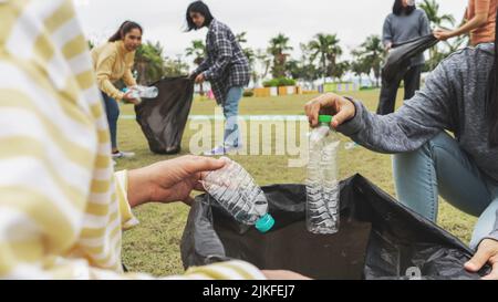 Asia Woman Group Team Volunteer Pick up Trash Plastics Müll Plastikmüll. Freund, der Plastikmüll im Park Concept Team Vo in die Tüte legt Stockfoto