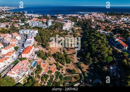 Luftdrohnenaufnahme des Wanderweges Ribeira das Vinhas in Cascais, Portugal mit der Bucht von Cascais im Hintergrund Stockfoto