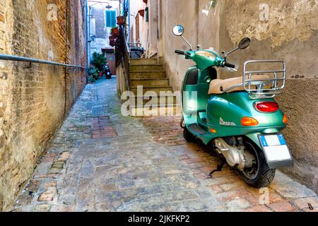 Grüne Vespa in einer kleinen Gasse in Penne, Italien Stockfoto