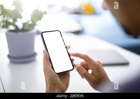 Mann mit Smartphone leerem Bildschirm rahmenlos modern - helles Zuhause Interieur Stockfoto