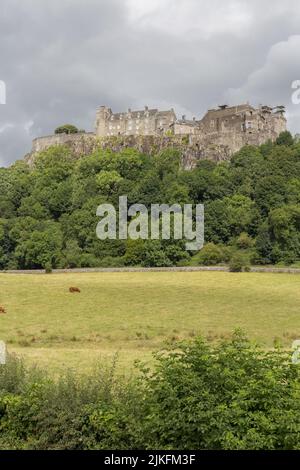 Eine vertikale Aufnahme eines alten Schlosses, das auf einem Felsen gebaut wurde, umgeben von grünen Bäumen, Schottland, Großbritannien Stockfoto
