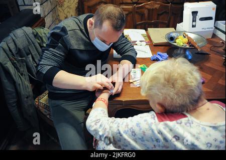 Private Krankenschwester führt zu Hause einen Bluttest bei einer älteren Person durch. Stockfoto