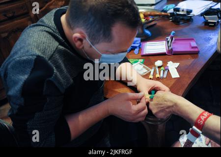 Private Krankenschwester führt zu Hause einen Bluttest bei einer älteren Person durch. Stockfoto
