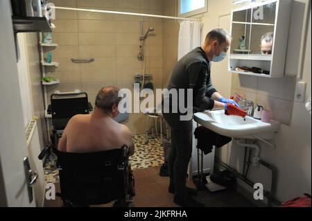 Eine private Krankenschwester führt im Haus eines 69-jährigen Patienten eine komplette Toilette durch. Stockfoto