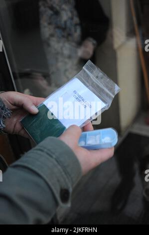 Freizügige Krankenschwester bei einem Patienten zu Hause für die Durchführung eines PCR-Tests. Stockfoto