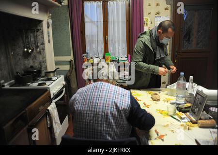 Private Krankenschwester im Haus eines 80-jährigen Patienten für die Montage von Kompressionsstrümpfen und einer Insulininspritze. Stockfoto