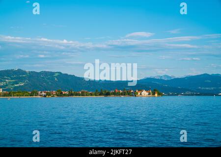 Deutschland, Lindau Stadthäuser am bodensee bei warmem Sonnenuntergang Sonnenlicht im Sommer, Panoramablick auf die alpen Berge Stockfoto