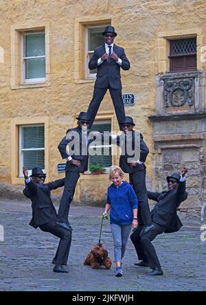 Dean Village, Edinburgh, Schottland, Großbritannien. 2.. August 2022. Die Black Blues Brothers kehren nach Edinburgh Fringe im Sommer zurück. Im Bild: Susie Macleod macht ihren Morgenspaziergang mit ihrem Labradoodle-Hund Lajla. Diese unglaubliche Truppe afrikanischer Akrobaten hat das Publikum auf der ganzen Welt begeistert und für Papst Franziskus im Vatikan und die britische Königsfamilie bei der Royal Variety Show aufgetreten. Tanz, Physical Theatre und Zirkus sind alle in ihrer Vorstellung in der Assembly Rooms Music Hall vom 3. Bis 28. August enthalten. Kredit: Archwhite/alamy Live Nachrichten. Stockfoto