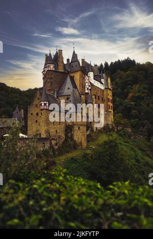 Eine vertikale Aufnahme des Schlosses Eltz, umgeben von grüner Vegetation. Wierschem, Deutschland. Stockfoto