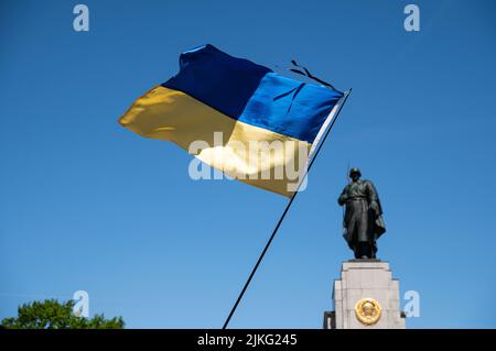 08.05.2022, Deutschland, Berlin, Berlin - Europa - Eine ukrainische Flagge fliegt am sowjetischen Denkmal entlang der Straße des 17. Juni im Großen Tiergarten während t Stockfoto