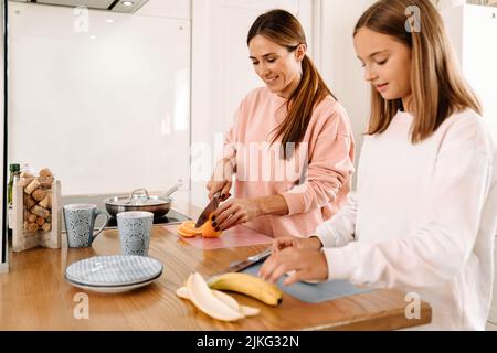 Weiße Mutter und Tochter kochen zusammen in der Küche zu Hause Stockfoto
