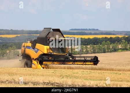 REGION KHARKIV, UKRAINE - 30. JULI 2022 - Ein Mähdrescher sammelt während der Erntezeit, die im nördlichen Teil von im Gange ist, Getreideernte Stockfoto