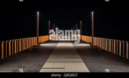 Pier (Molo di Alassio) in der Stadt Alassio, an der Küste des Ligurischen Meeres in der Provinz Savona, Norditalien bei Nacht Stockfoto