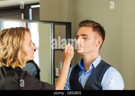 Make-up für den Menschen, Hände des Make-up-Künstlers, Pinsel Stockfoto