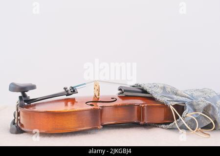 Akustische Geige in einer Seidentasche auf einem weißen Schreibtisch mit Platz für Text Stockfoto