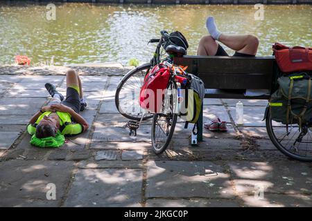 Radler, der sich im Schatten am Fluss Ouse, York, Großbritannien, ausruhen kann. Sommerhitze in York. Eine neue britische Rekordtemperatur von 40,3C wurde tagsüber in Lincolnshire eingestellt. York, 2022, Großbritannien. Stockfoto