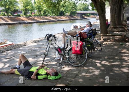 Radler, der sich im Schatten am Fluss Ouse, York, Großbritannien, ausruhen kann. Sommerhitze in York. Eine neue britische Rekordtemperatur von 40,3C wurde tagsüber in Lincolnshire eingestellt. York, 2022, Großbritannien. Stockfoto