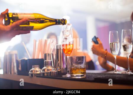 Aperol Spritz-Cocktail. Alkoholisches Getränk, basierend auf Tabelle mit Eiswürfeln und Orangen. Stockfoto