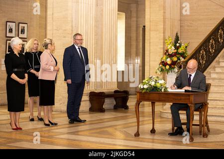 (Von links nach rechts) DUP MLA Joanna Bunting, Clerk/Chief Executive der nordirischen Versammlung Lesley Hogg, Sinn Fein-Vizepräsidentin Michelle O'Neill und UUP-Vorsitzende Doug Beattie MLA sehen zu, wie der Parlamentspräsident Alex Maskey eine Botschaft in das Kondolenzbuch schreibt: In der Großen Halle des Parlaments in Stormont für den ehemaligen nordirischen Ersten Minister und Führer der Ulster Unionist Party (UUP) Lord David Trimble, der letzte Woche im Alter von 77 Jahren starb. Bilddatum: Dienstag, 2. August 2022. Stockfoto