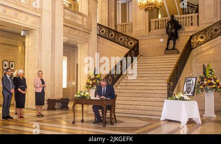 (Von links nach rechts) Alliance MLA Andrew Muir, DUP MLA Joanne Bunting, Und die Vizepräsidentin der Sinn Fein, Michelle O'Neill, blickt auf Doug Beattie MLA, den Vorsitzenden der UUP, als er in der Großen Halle der Parlamentsgebäude in Stormont das Kondolenzbuch für den ehemaligen nordirischen Ersten Minister und Vorsitzenden der Ulster Unionist Party (UUP), Lord David Trimble, unterschreibt, Die letzte Woche im Alter von 77 Jahren starb. Bilddatum: Dienstag, 2. August 2022. Stockfoto