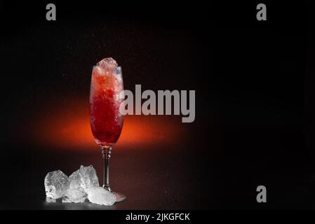 Granizado oder zerstoßenes Eis mit Fruchtsaft. Spanischer Granizado-Drink aus Obst Red Slush Drink isoliert auf schwarzem Hintergrund. Eine sommerliche Erfrischung Stockfoto