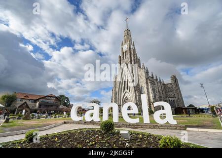 Canela, RS, Brasilien - 19. Mai 2022: Der Stadtname Totem vor der Steinkathedrale, Catedral de Pedra auf portugiesisch. Die Nossa Senhora de Lourdes Stockfoto