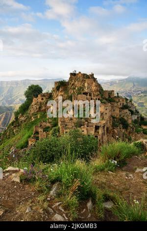 Altes Dorf Gamsutl auf Felsen auf dem Hintergrund der Berge. Erstaunliche Siedlung von Felshäusern auf dem Gipfel des Berges. Attraktion von Dagestan - Dorf von Stockfoto