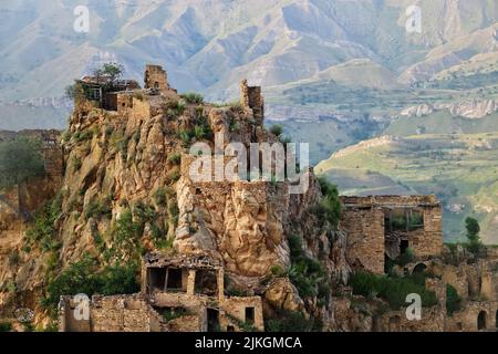 Altes Dorf Gamsutl auf Felsen auf dem Hintergrund der Berge. Erstaunliche Siedlung von Felshäusern auf dem Gipfel des Berges. Attraktion von Dagestan - Dorf von Stockfoto