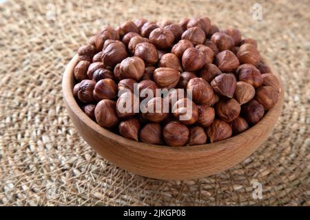 Nahaufnahme einer Schüssel voller Haselnüsse auf dem Weidenkorb Stockfoto