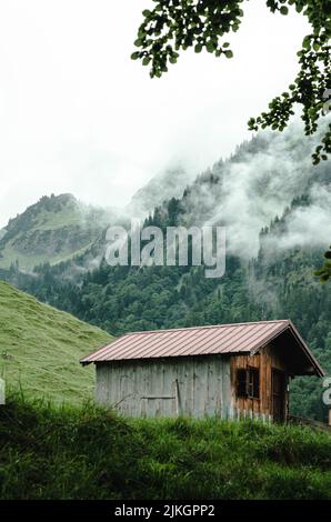 Eine vertikale Aufnahme einer Holzhütte in den Bergen von Oytal, Obesrtdorf, Allgau, Bayern, Deutschland Stockfoto