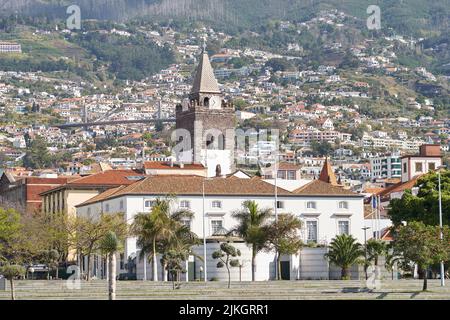 Die Kathedrale von Funchal mit Häusern auf den Hügeln im Hintergrund in SE, Funchal, Madeira, Portugal Stockfoto