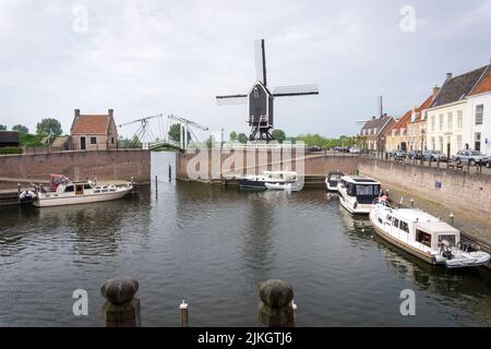 Heusden, Brabant, Niederlande - 7. Mai 2022: Zugbrücke und Windmühle am Hafen in der niederländischen Festungsstadt Heusden. Stockfoto