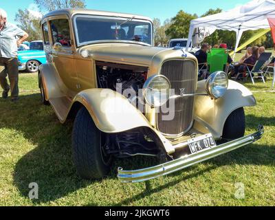 Chascomus, Argentinien - 9. Apr 2022: Alter beiger Ford Model B 18 V8 Tudor Limousine 1932. Natur grünes Gras und Bäume. Oldtimer-Show. Copyspace Stockfoto