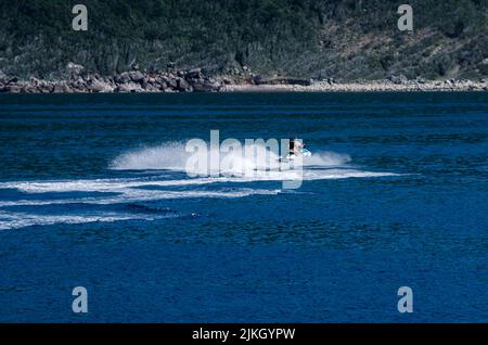 Eine wunderschöne Aufnahme von Menschen, die auf einem Jet-Ski in einem blauen See reiten Stockfoto