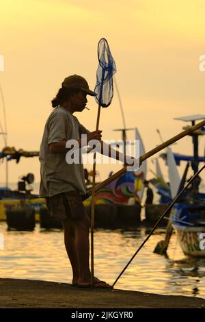 Menschen, die im stromabwärts gelegenen Fluss fischen, fängt er kleine Fische und Garnelen Stockfoto