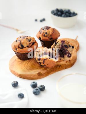 Eine vertikale Aufnahme von hausgemachten leckeren Blaubeer-Muffins mit einem aufgebrochenen Stockfoto