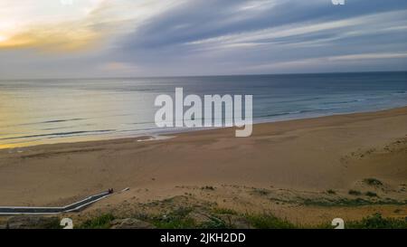 Ein ruhiger Sandstrand unter blauem Himmel in Tanger, Marokko Stockfoto