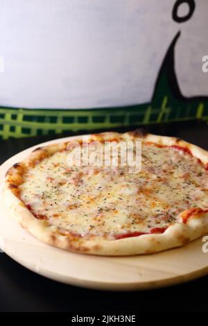 Eine vertikale Aufnahme von Margherita Pizza mit Tomatenmark und Käseüberlagen Stockfoto