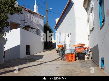 Raposeira, Portugal. 20.. Juli 2022. Baustellenausrüstung steht zwischen zwei renovierten Häusern in einer Gasse in einem Dorf an der Algarve. Quelle: Viola Lopes/dpa/Alamy Live News Stockfoto