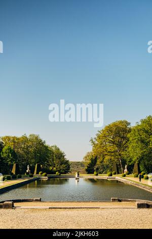 Eine vertikale Aufnahme des Gartens des Chateau de Breteuil in Choisel, Frankreich in blauem Himmel Hintergrund Stockfoto