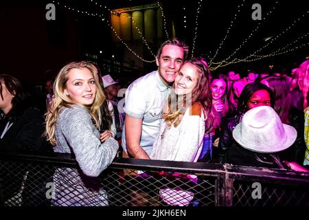 Trendige junge Leute, die an einem Musikkonzert teilnehmen Stockfoto