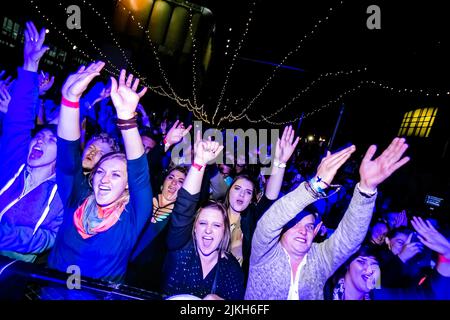 Trendige junge Leute, die an einem Musikkonzert teilnehmen Stockfoto