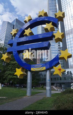 Aktivisten haben ein Banner auf dem EURO-Denkmal in Frankfurt angebracht, um den Beitritt der Ukraine zur EU zu unterstützen. Andere haben rote Farbbeutel geworfen. Stockfoto