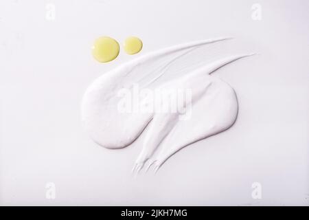 Ein Abstrich von Creme- und Öltropfen isoliert auf weißem Hintergrund Stockfoto