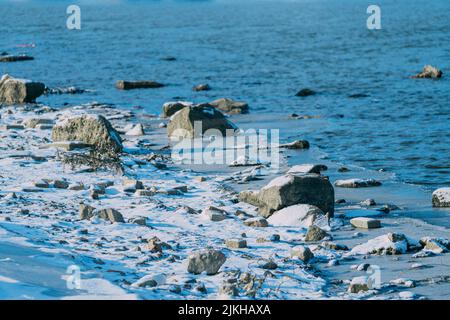Ein schöner Strand mit Steinen im blauen Wasser Stockfoto