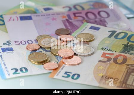 Viele Euro-Münzen auf Euro-Banknoten Stockfoto