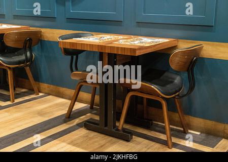 Ein leerer kleiner, gemütlicher Tisch und zwei Stühle in einem guten Restaurant Stockfoto